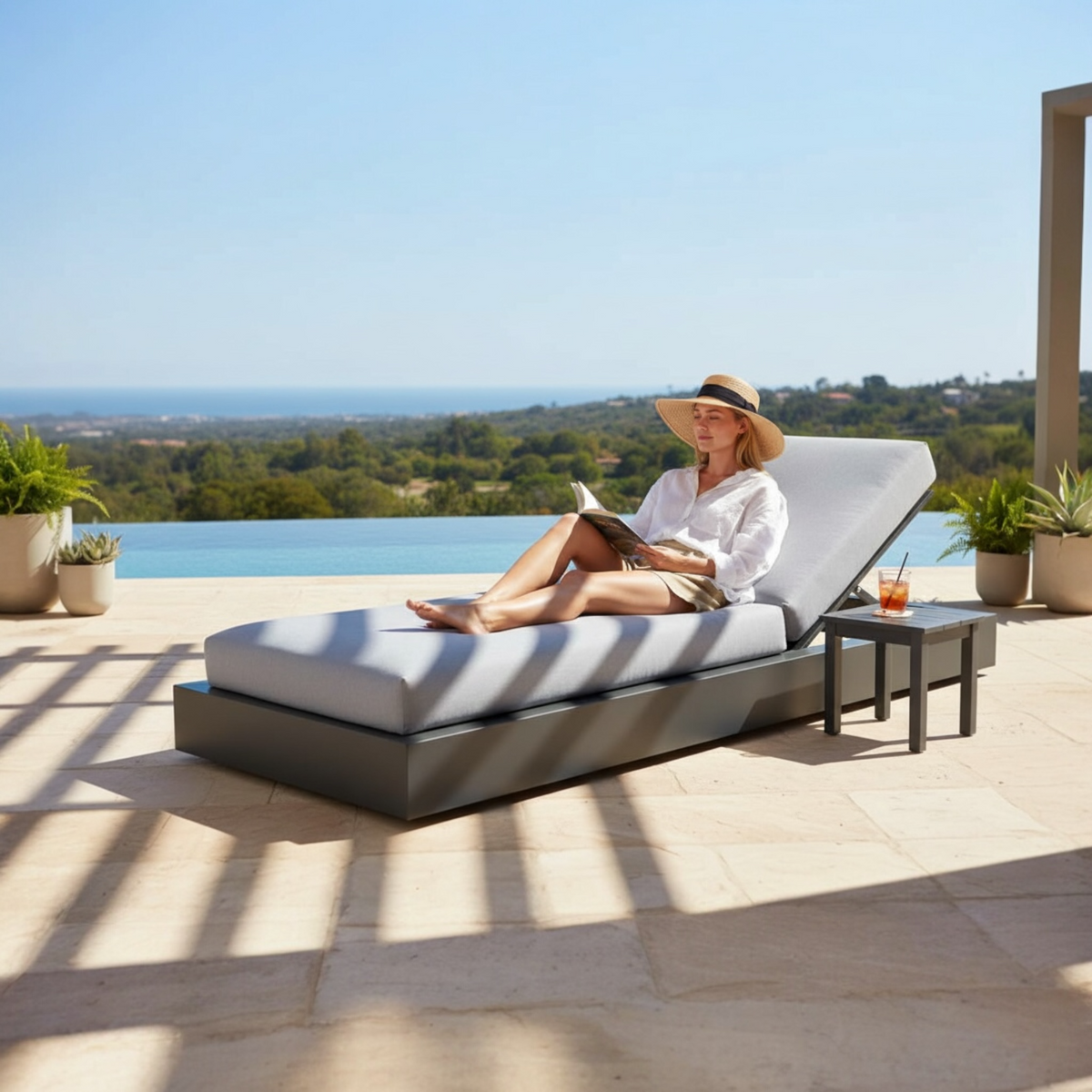 Como Bed black aluminum sunbed with padded cushion – shown outdoors