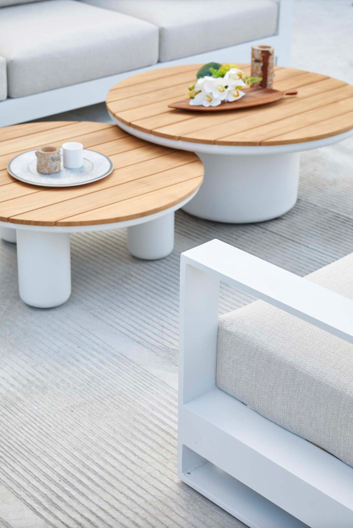 Coffee table from the Iris Cosy white aluminum outdoor sectional with extra-wide corner seat – shown outdoors