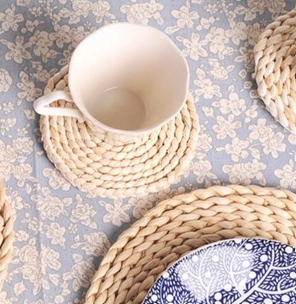 Round woven rattan coaster – shown in a room setting