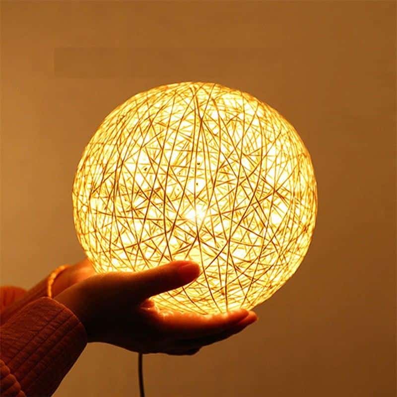 Hand-braided rattan ball LED bedside lamp – shown in use
