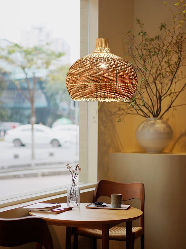 Vintage round rattan pendant light with wood accents – shown in a room setting (2)