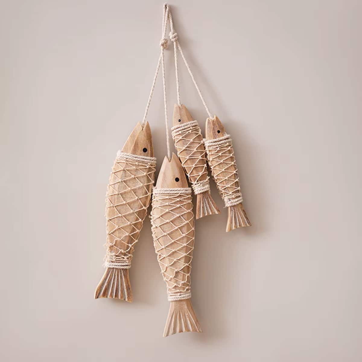 Set of two carved wooden fish wall decorations – shown in a room setting
