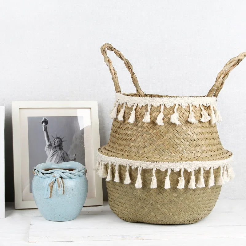 Rounded wicker basket trimmed with cotton tassels – shown in a room setting