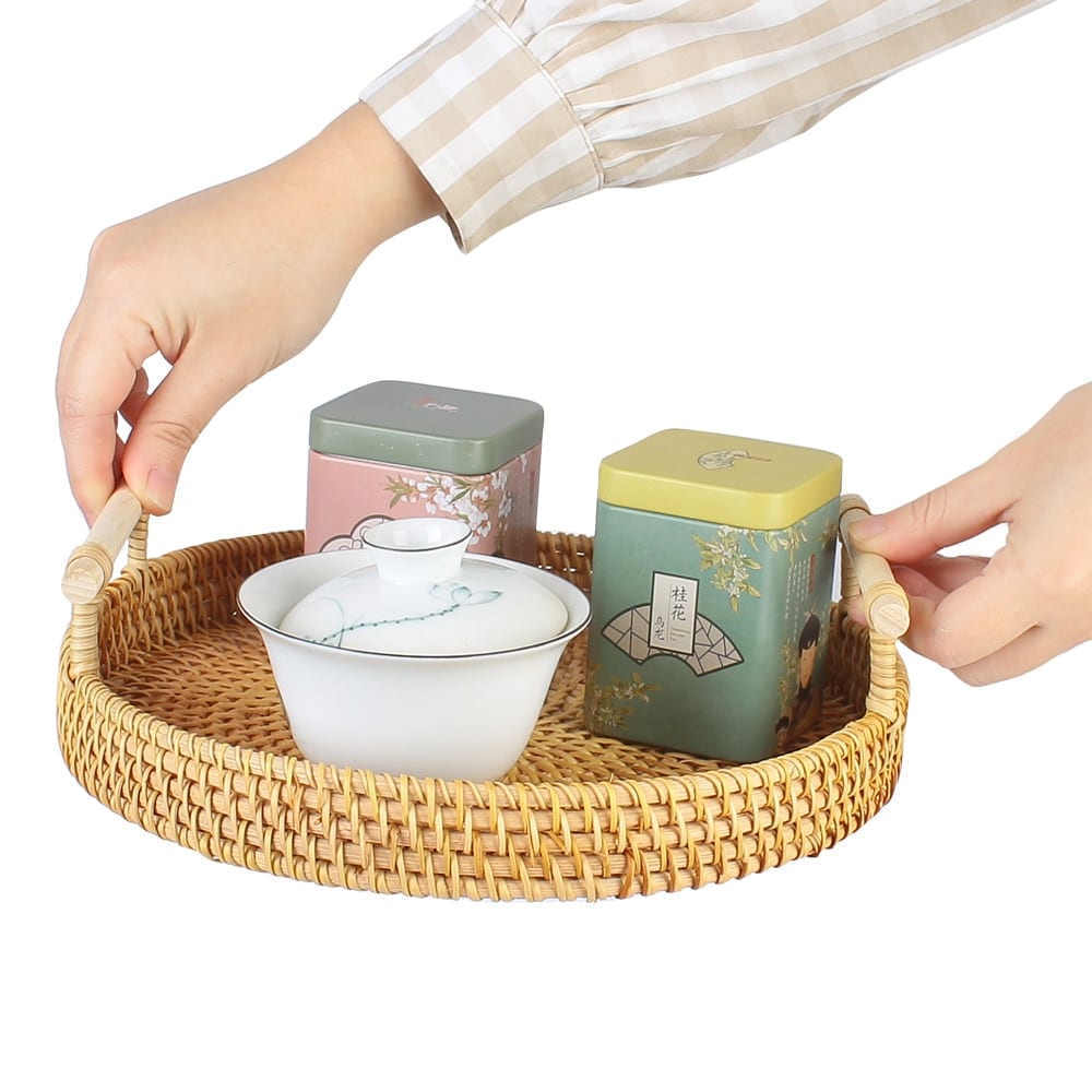 Round hand-braided rattan tray with a curved center handle – shown in use