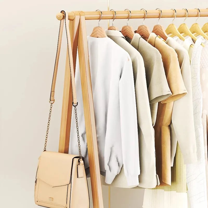 Two-tier wood and bamboo clothing rack with staggered rails – shown in a room setting (2)