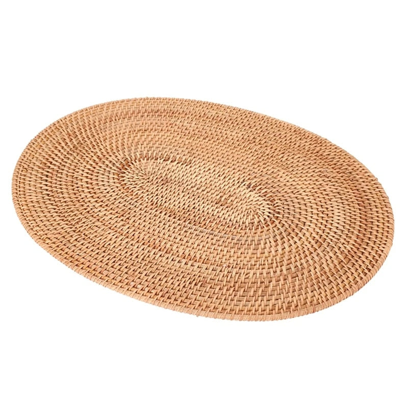 Oval natural rattan placemat in an untreated honey tone