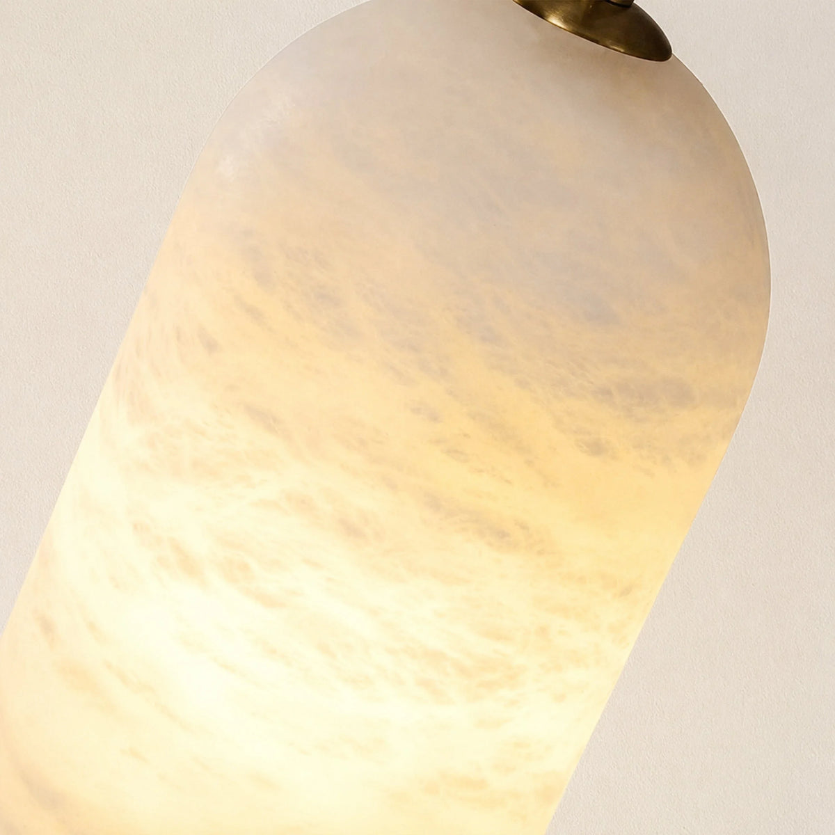 Tarente translucent marble pendant light with brushed brass canopy – close-up detail, lit