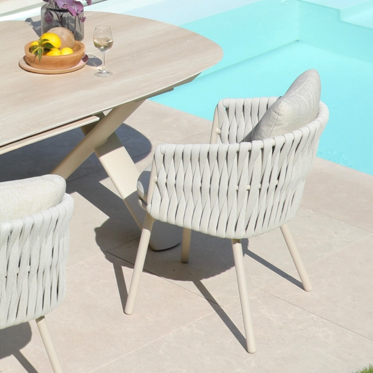 Livio beige aluminum and rope outdoor dining armchair – shown outdoors (2)
