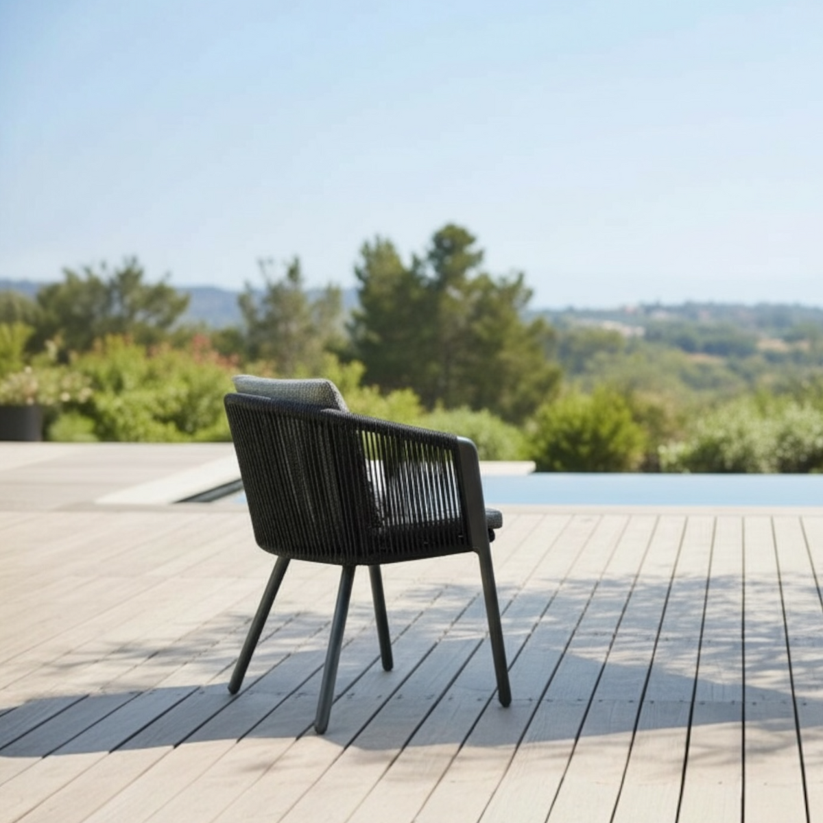 Livio black aluminum and rope outdoor dining armchair – shown outdoors