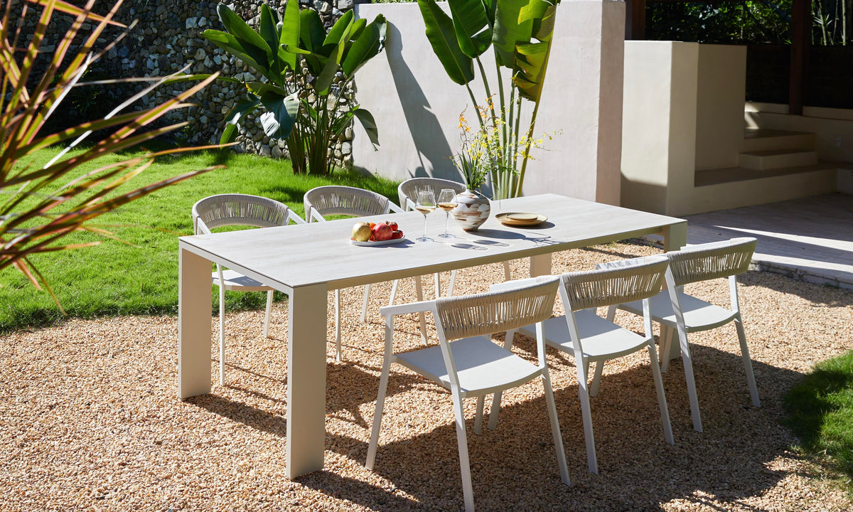 Jules pearl gray ceramic and beige aluminum outdoor dining table – shown outdoors (4)