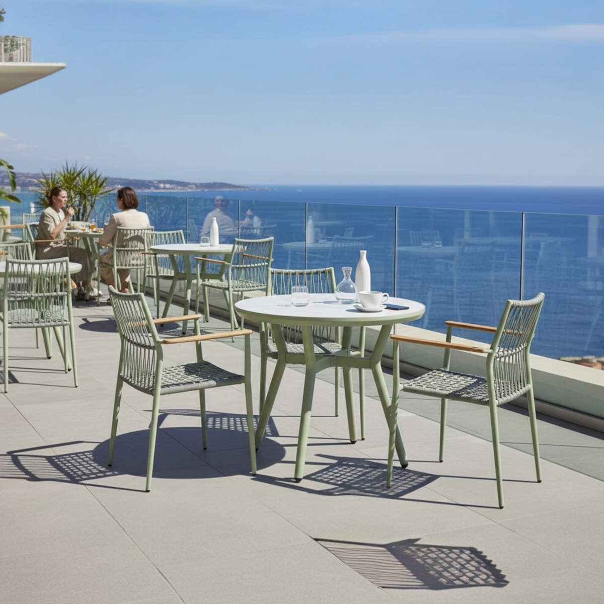 Sarran green round ceramic-top restaurant table, 90 cm – shown outdoors