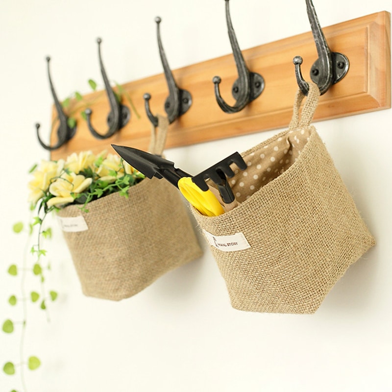 Hanging cotton and linen storage pocket with a reinforced handle – shown in a room setting
