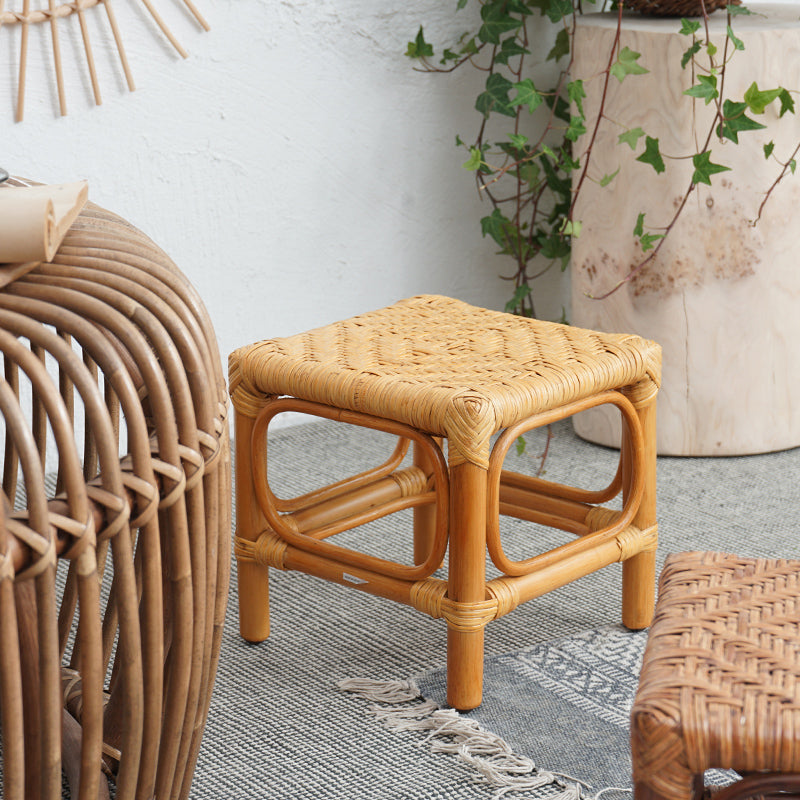 Light wood footstool with a hand-braided rattan top – shown in a room setting