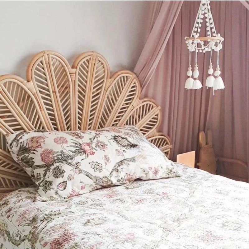 Rattan headboard with hand-braided fanned petals – shown in a room setting
